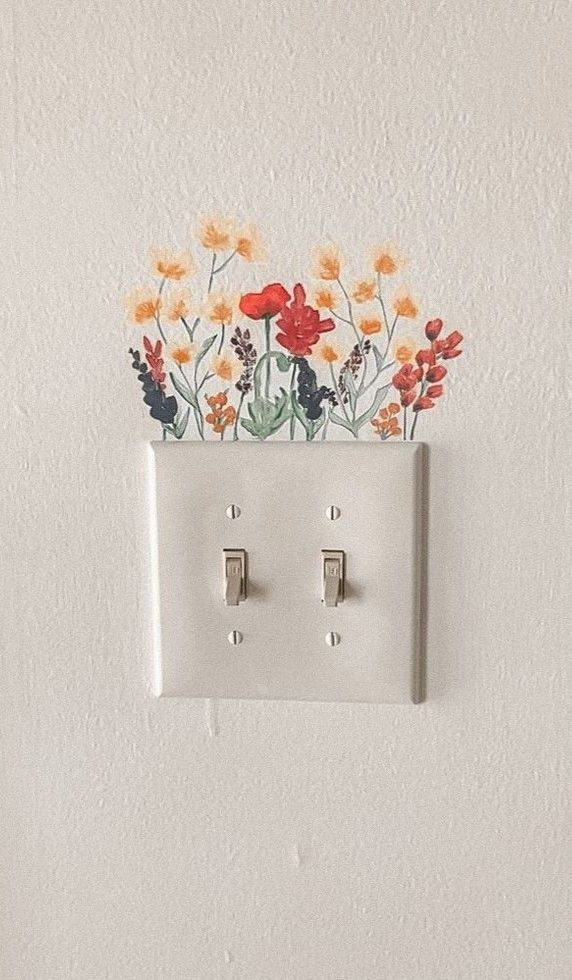 Ein Lichtschalter mit gemalten Blumen darüber